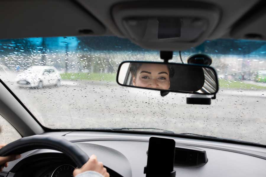 Bilförare tittar in i backspegeln