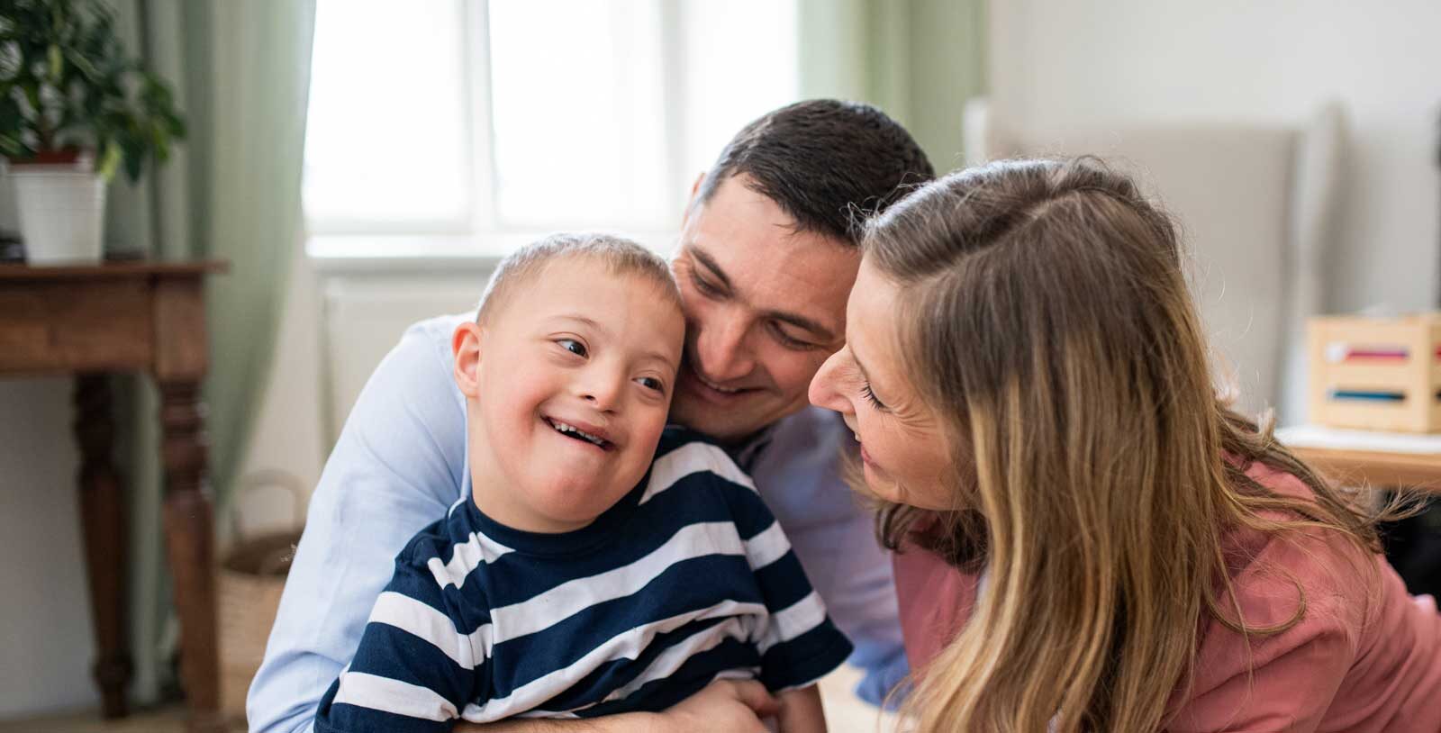 Pojke med downs syndrom och föräldrar. Foto: Envato Elements