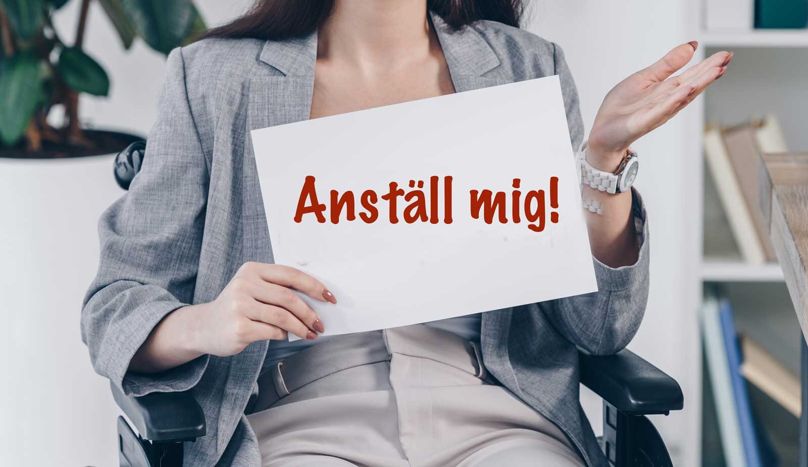 Kvinna i rullstol med skylt: Anställ mig